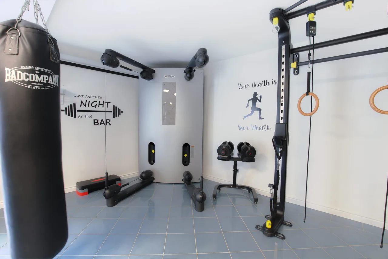 Kraftstation, Hanteln und Boxsack im Fitnessraum