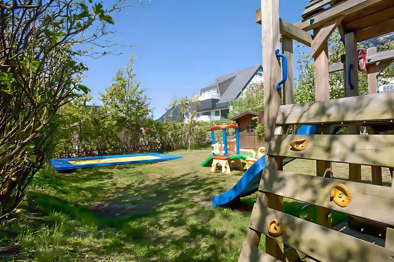 Spielplatz mit Trampolin, Rutsche, Schaukel und Sandkasten